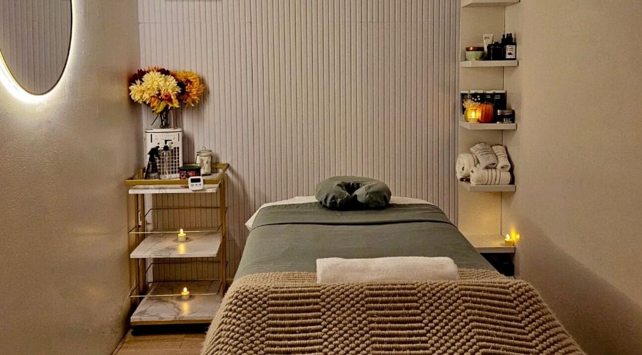Relaxing massage room at Aura Sanctuary, New York, New York, US with cozy decor and ambient lighting.
