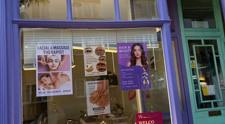 Blush hair&beauty in London, England, GB offers facial, massage, and hair services seen through colorful window posters.