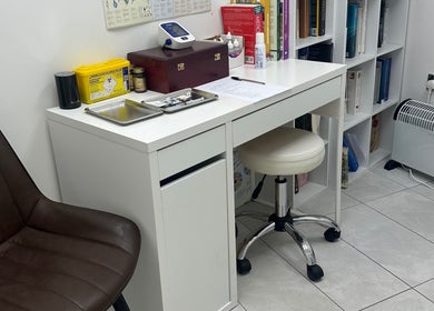 Consultation room at Wellness Space Lifestyle Medicine, Glasgow, Scotland, GB with chair, desk, and medical equipment.