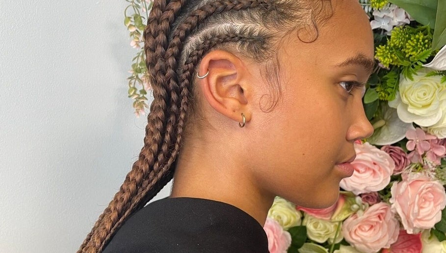 Stylish braids at Hair by M in Brentwood, England, GB against a floral backdrop.