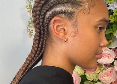 Stylish braids at Hair by M in Brentwood, England, GB against a floral backdrop.