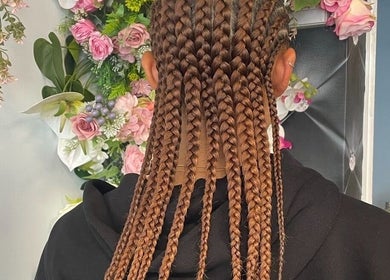 Intricate braiding at Hair by M, Brentwood, England, GB with floral decor background.