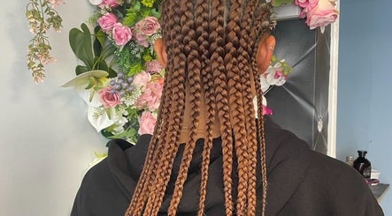 Intricate braiding at Hair by M, Brentwood, England, GB with floral decor background.