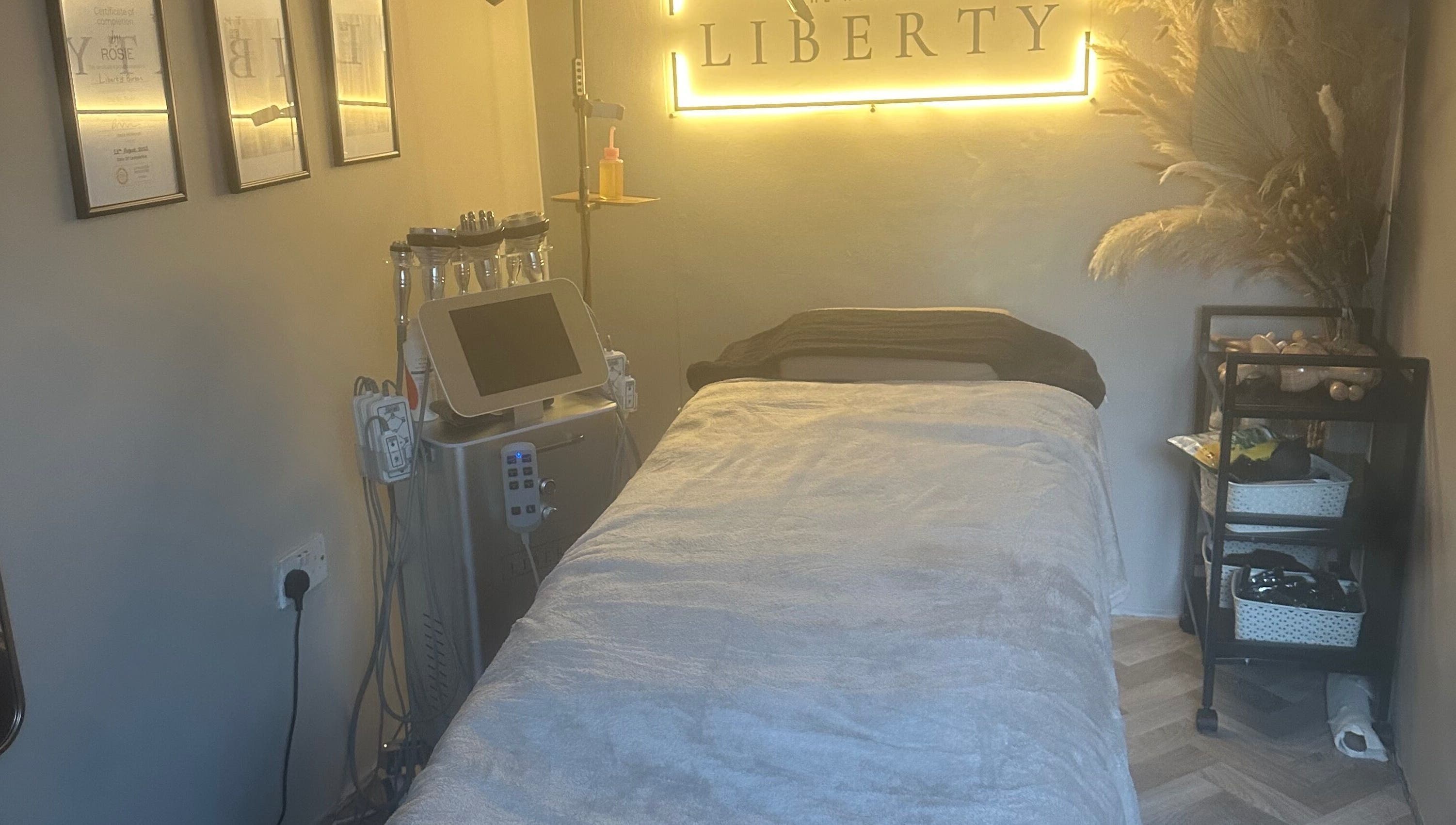 Relaxing treatment room at The House of Liberty, Feltham, England, GB, featuring a plush bed and soothing decor.