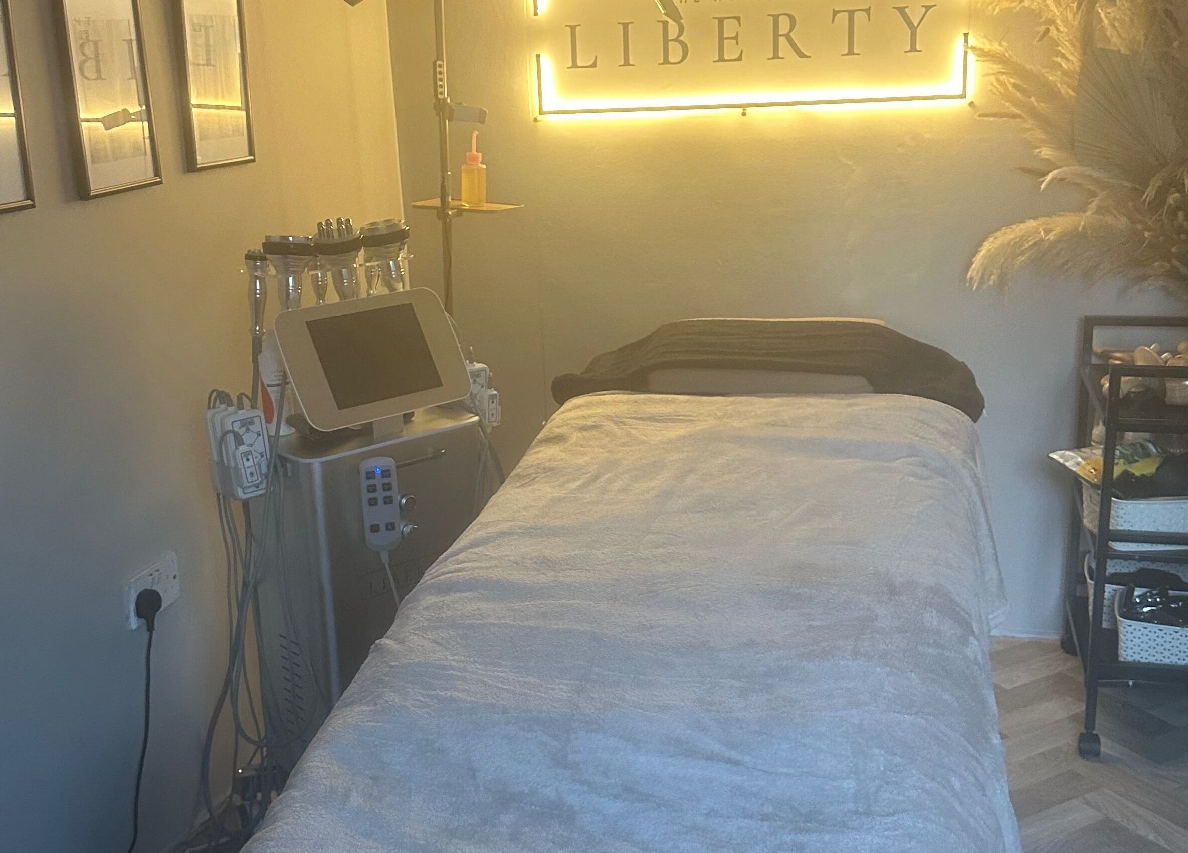 Relaxing treatment room at The House of Liberty, Feltham, England, GB, featuring a plush bed and soothing decor.