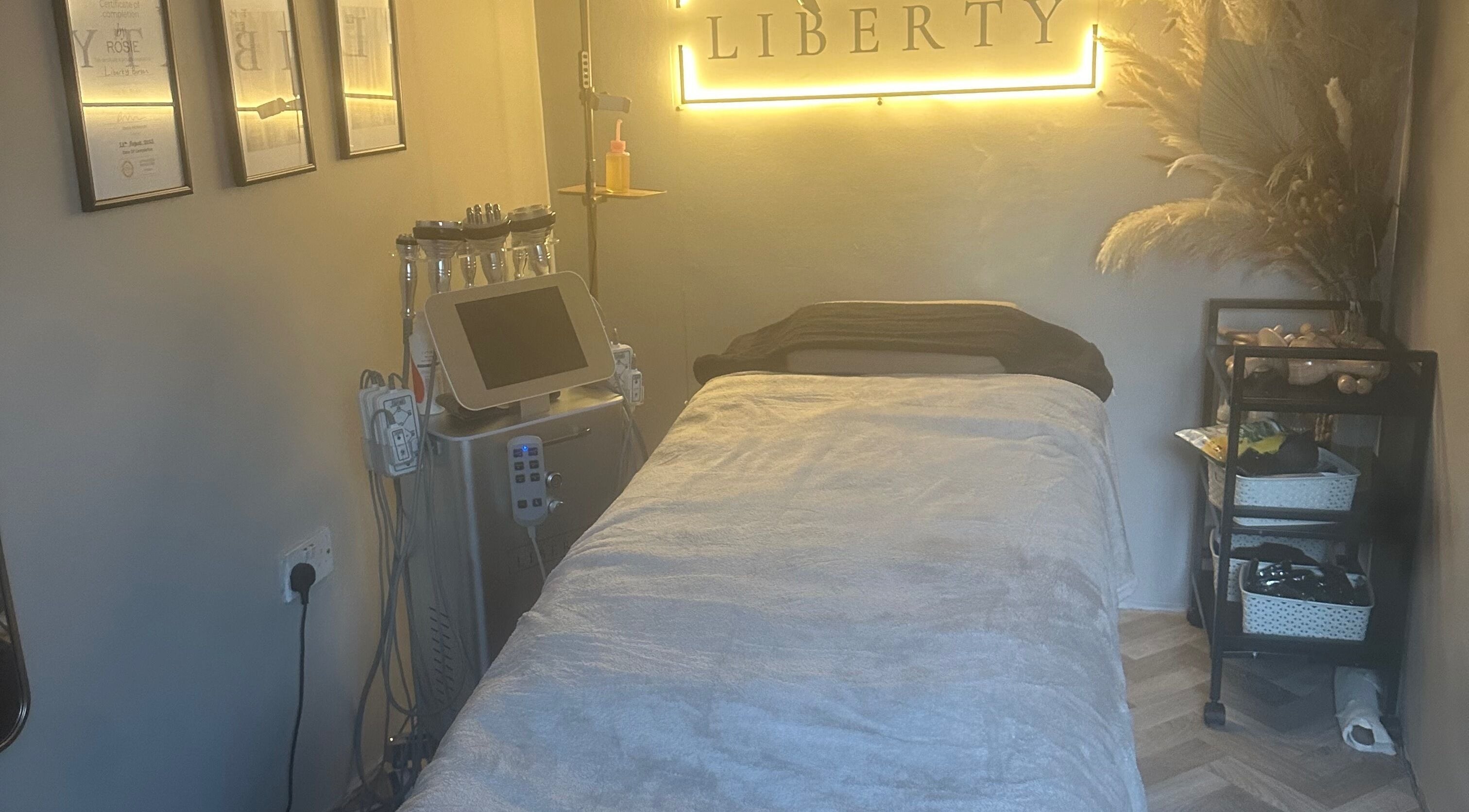 Relaxing treatment room at The House of Liberty, Feltham, England, GB, featuring a plush bed and soothing decor.