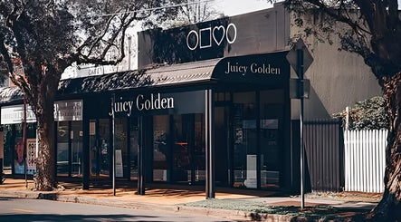 Street view of Juicy Golden beauty venue in Brisbane, Queensland, AU under leafy trees.