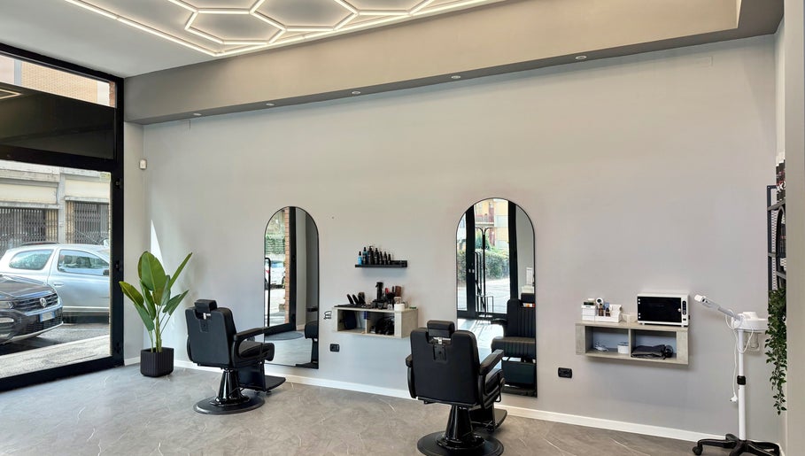 Interno di Barber d’Èlite, Firenze, Toscana, IT, con sedie da barbiere e design elegante.
