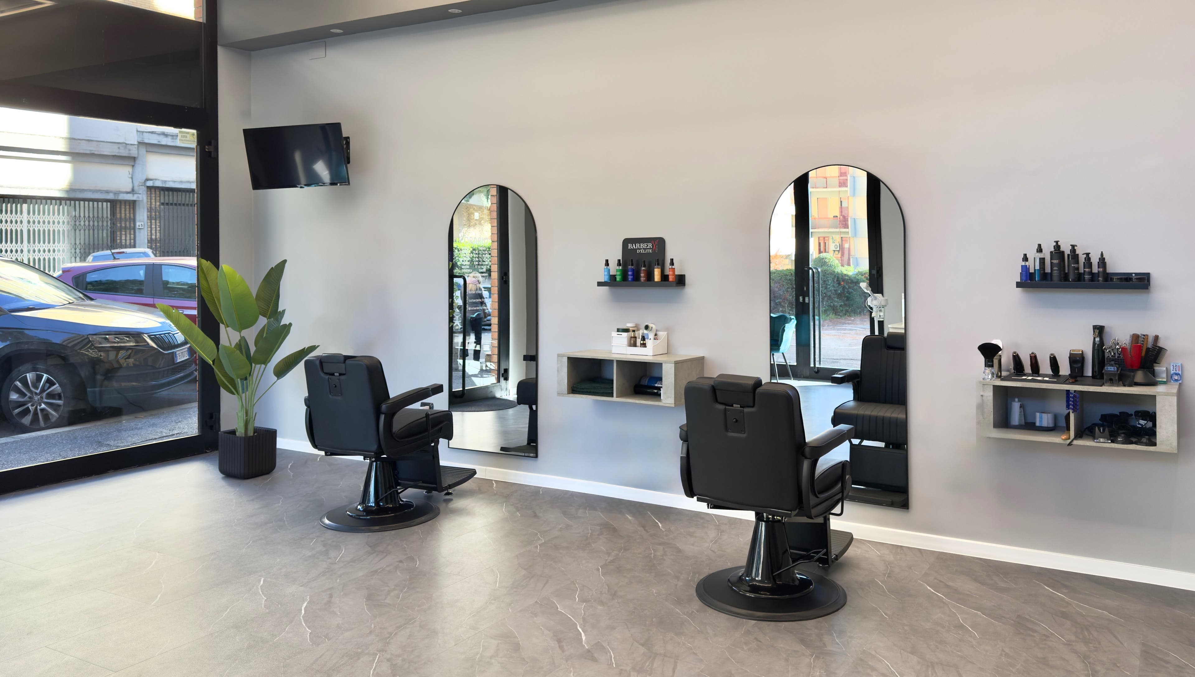 Interno moderno di Barber d’Èlite a Firenze, Toscana, IT con sedie confortevoli e decorazioni chic.