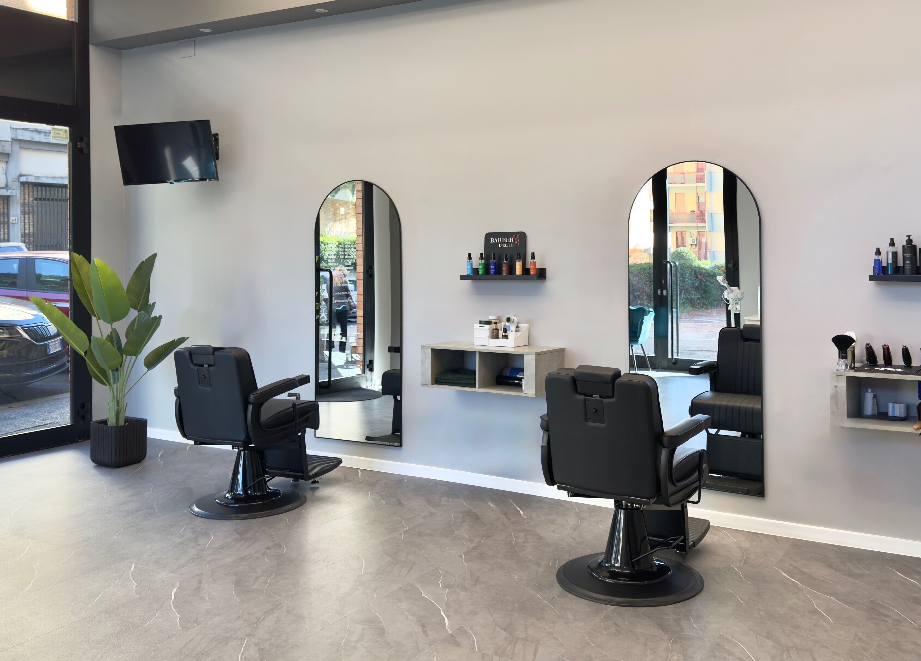 Interno moderno di Barber d’Èlite a Firenze, Toscana, IT con sedie confortevoli e decorazioni chic.