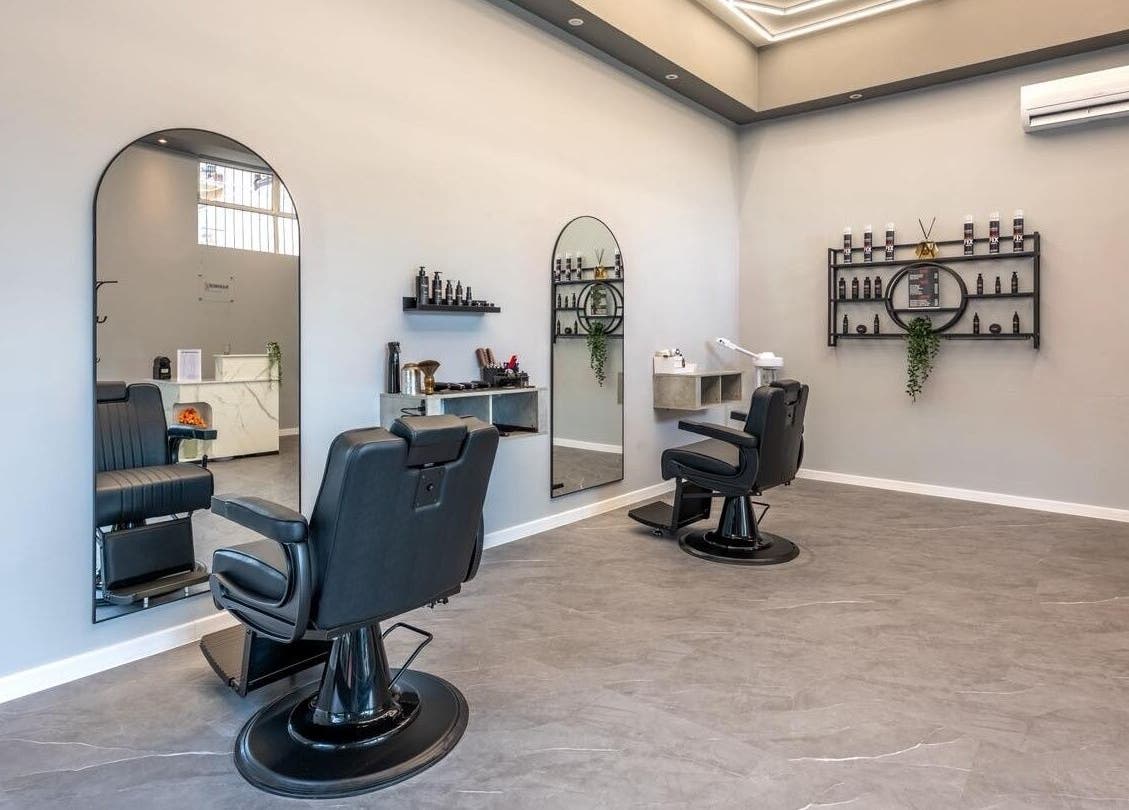 Interno elegante di Barber d’Èlite a Firenze, Toscana, IT, con postazioni e specchi moderni.