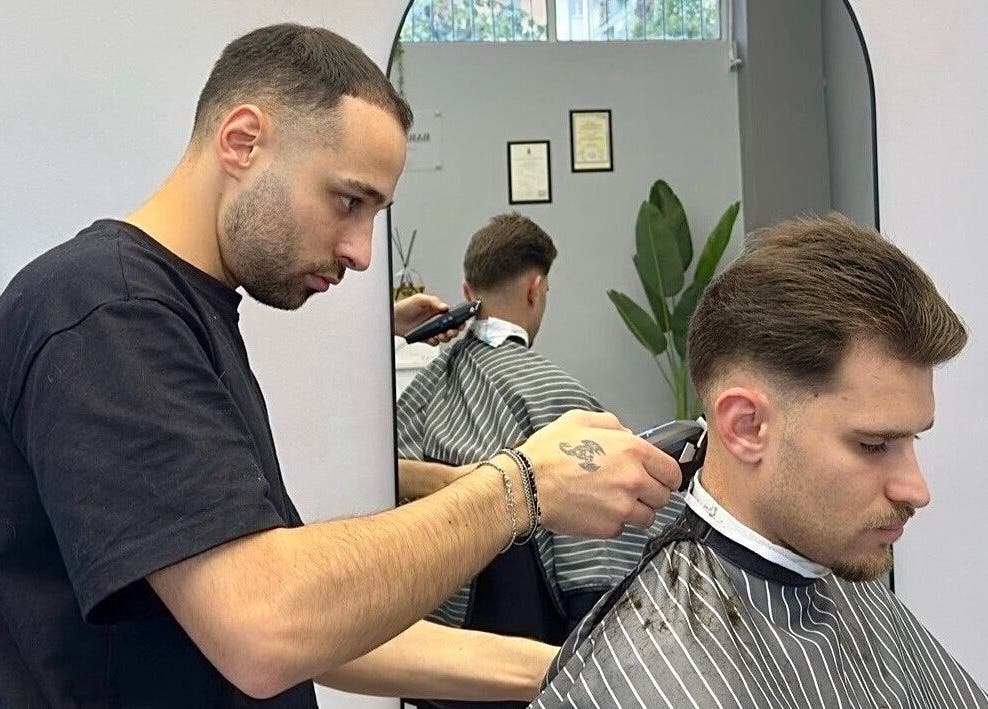 Barbiere che effettua un taglio maschile a Barber d’Èlite, Firenze, Toscana, IT.