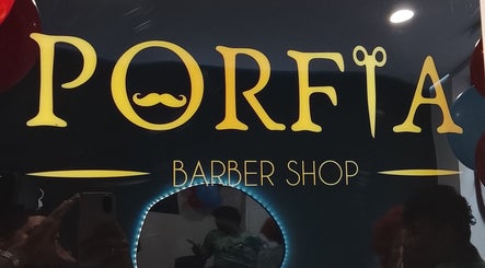 Placa da Barbearia Porfia em Guimarães, Braga, PT, com logotipo elegante e iluminação suave.