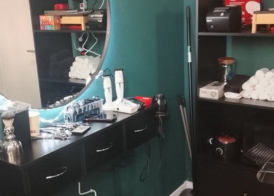 Estação de trabalho no Porfia BarberShop, Guimarães, Braga, PT, com espelho iluminado e equipamentos de barbear.