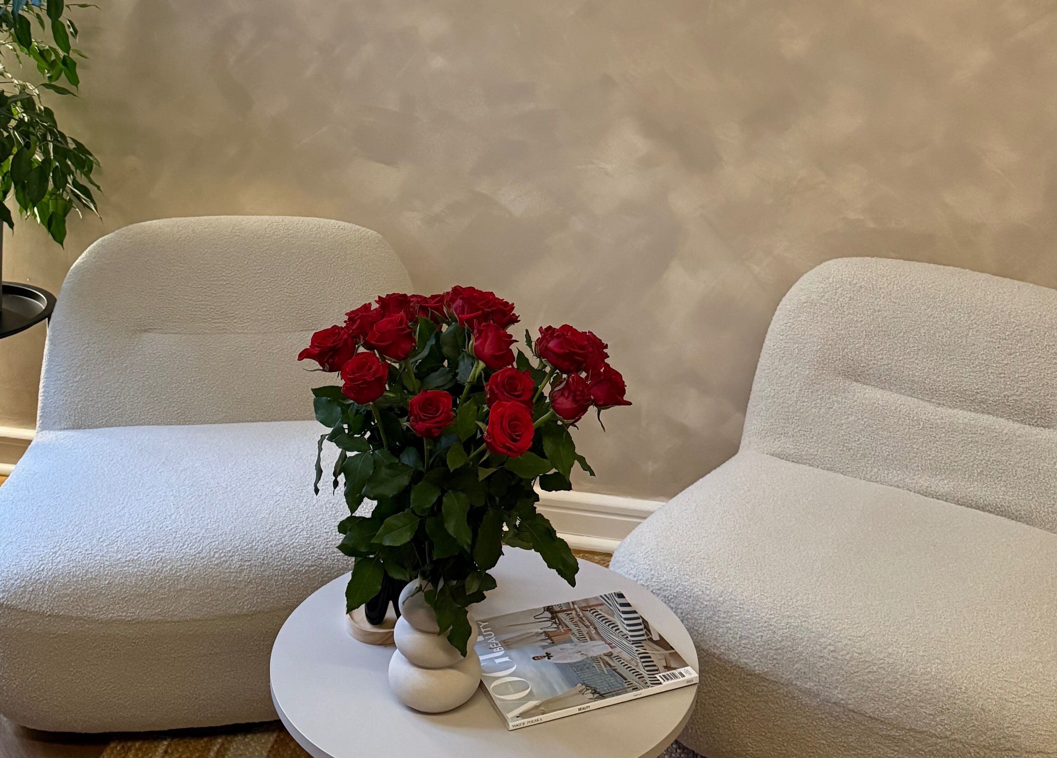 Elegancki kącik z białymi fotelami i czerwonymi różami w 7Heaven Lashes and Brows, Warszawa, Województwo Mazowieckie, PL.