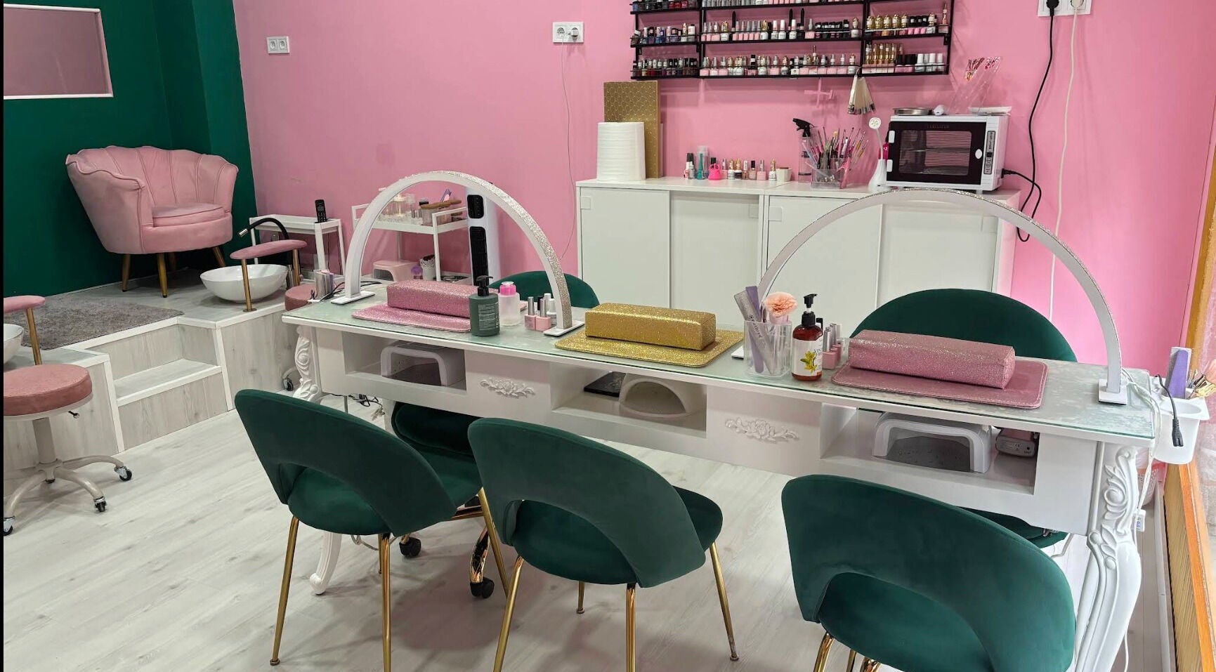 Interior de Cleopatra Nails con sillas verdes y ambiente elegante en Madrid, Comunidad De Madrid, ES.