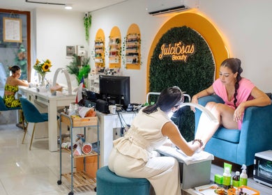Mujer recibe pedicura en Juiciosas Beauty, Tas-sliema, MT, destacando ambiente relajante y elegante.