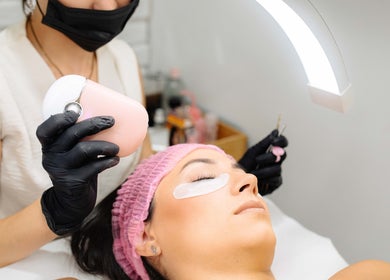 Tratamiento de belleza en Juiciosas Beauty, Tas-sliema, MT, con una especialista aplicando cuidados faciales.