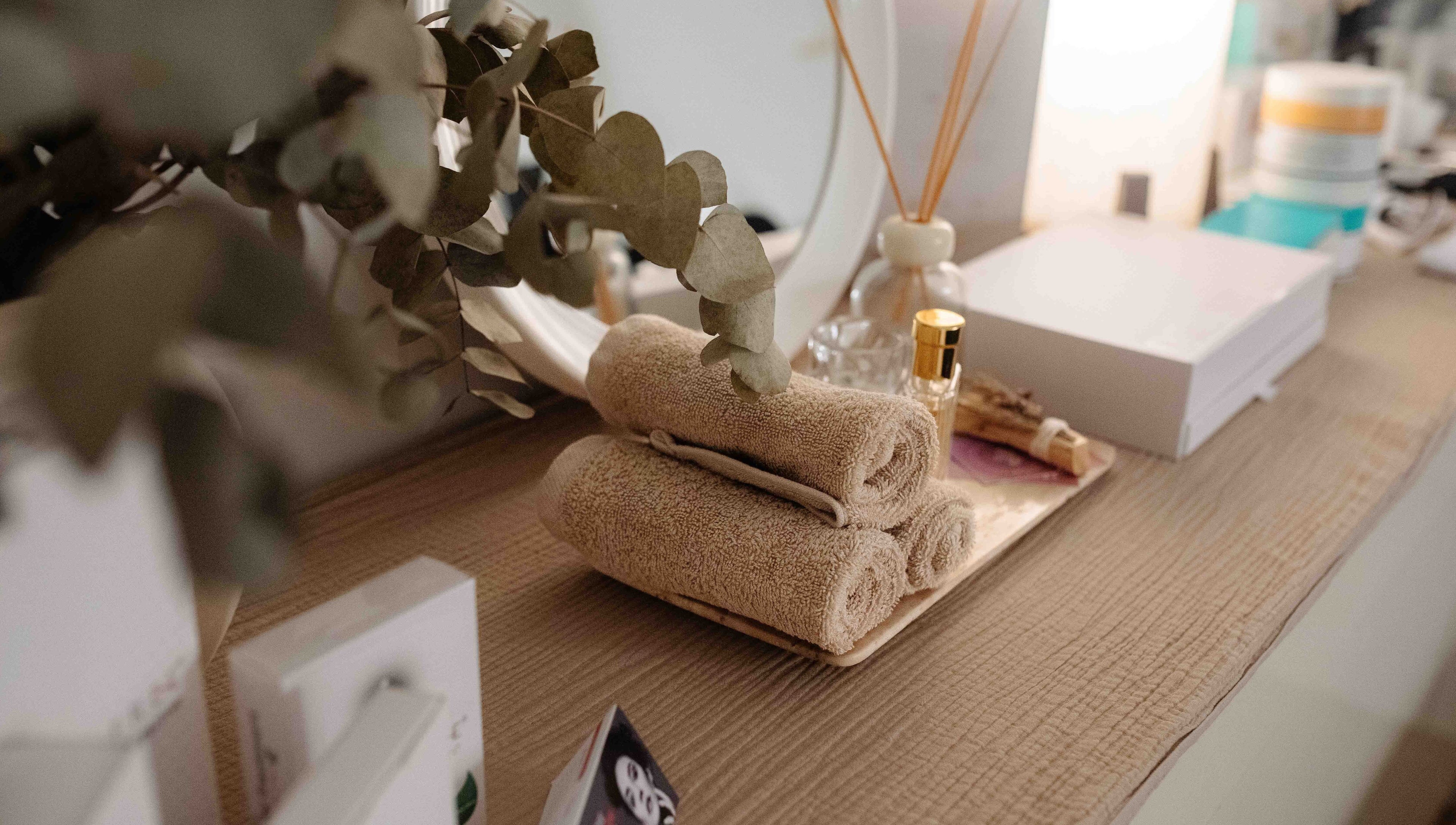 Toallas elegantes y eucalipto decoran un espacio en Juiciosas Beauty, Tas-sliema, MT.