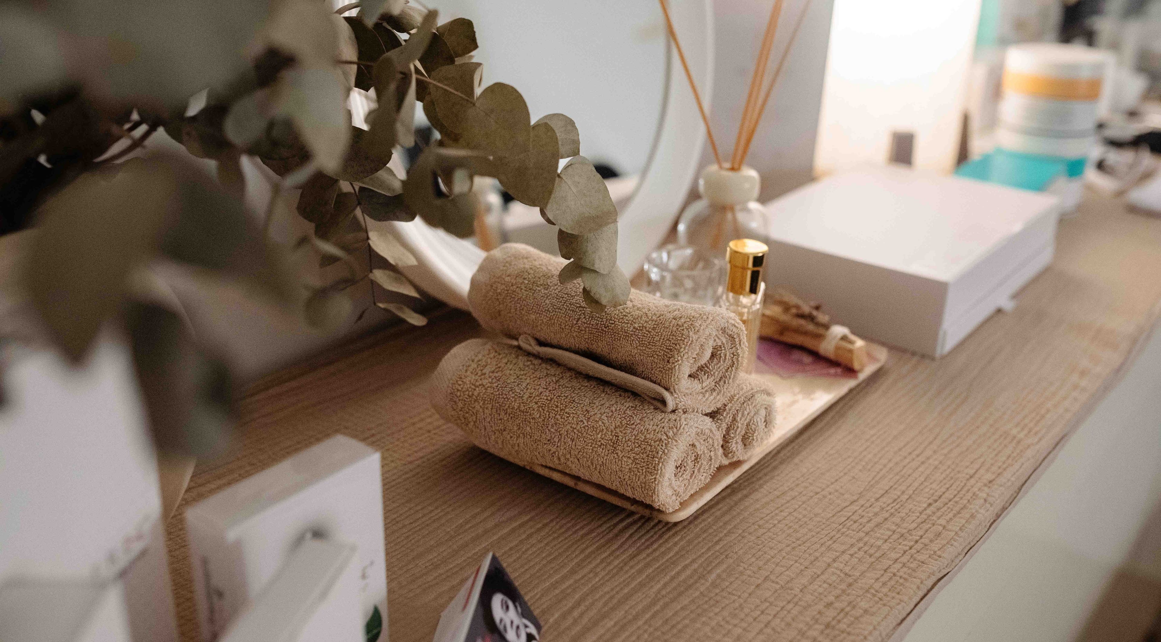Toallas elegantes y eucalipto decoran un espacio en Juiciosas Beauty, Tas-sliema, MT.