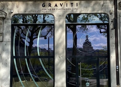 Entrée de GRAVITI Lyon 3 - Centre de Flottaison, reflet d'arbres sur les vitres. Adresse: Lyon, Auvergne-rhône-alpes, FR.