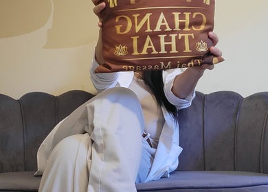 Guest holding Changthai Massage pillow on a plush couch at Bellinzona, Ticino, CH.