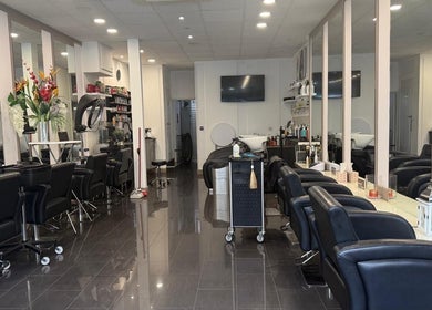 Adelle hairdresser salon interior in London, England, GB, featuring stylish chairs and mirrors.