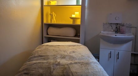Relaxation room at Chioma Beauty and Bodywork, London, England, GB with calm lighting and a comfortable massage bed.