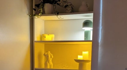 Elegant shelf decor at Chioma Beauty and Bodywork, London, England, GB, featuring soothing candles and gentle lighting.