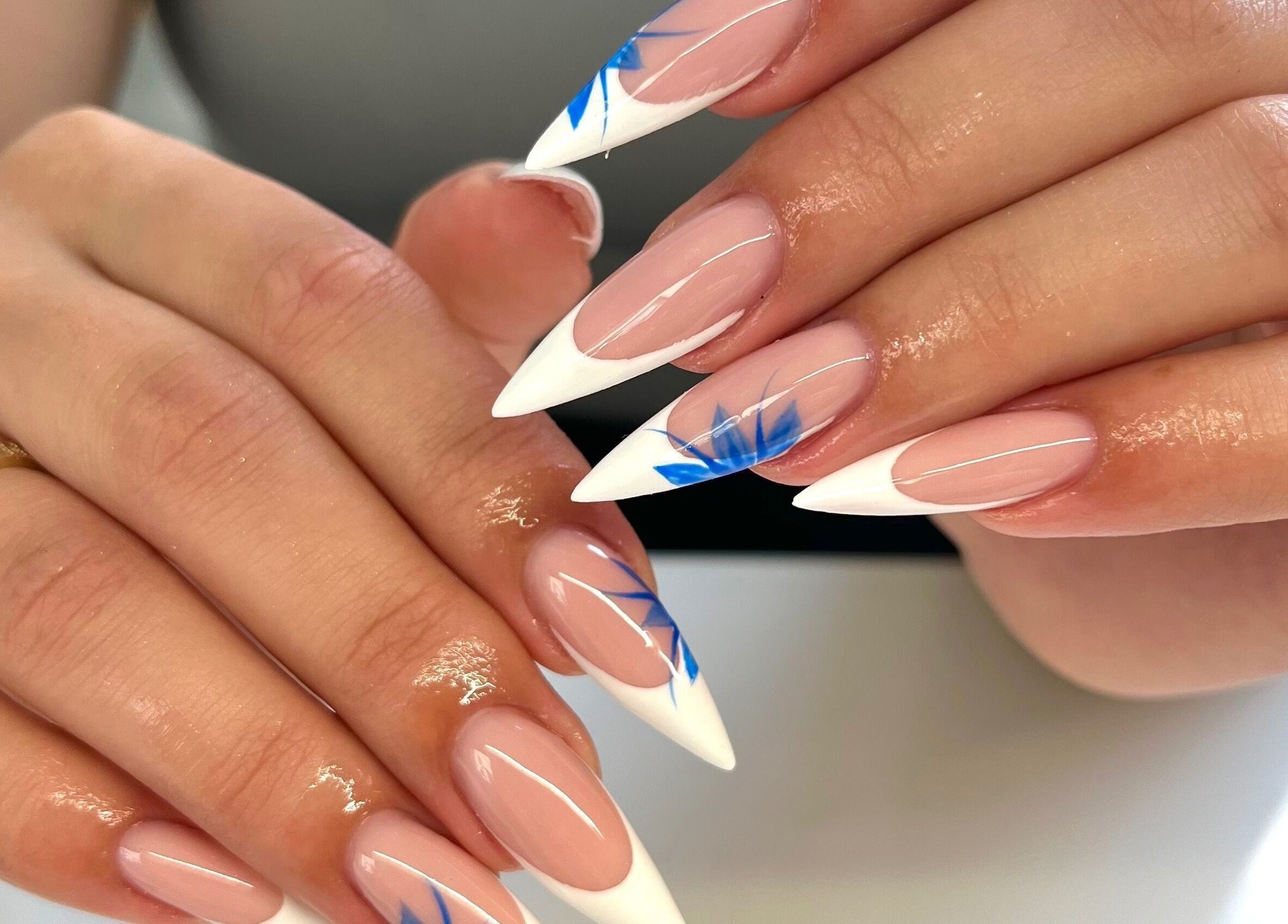 Elegant stiletto nails with blue accents by Nails by Ray, Chelmsford, England, GB.