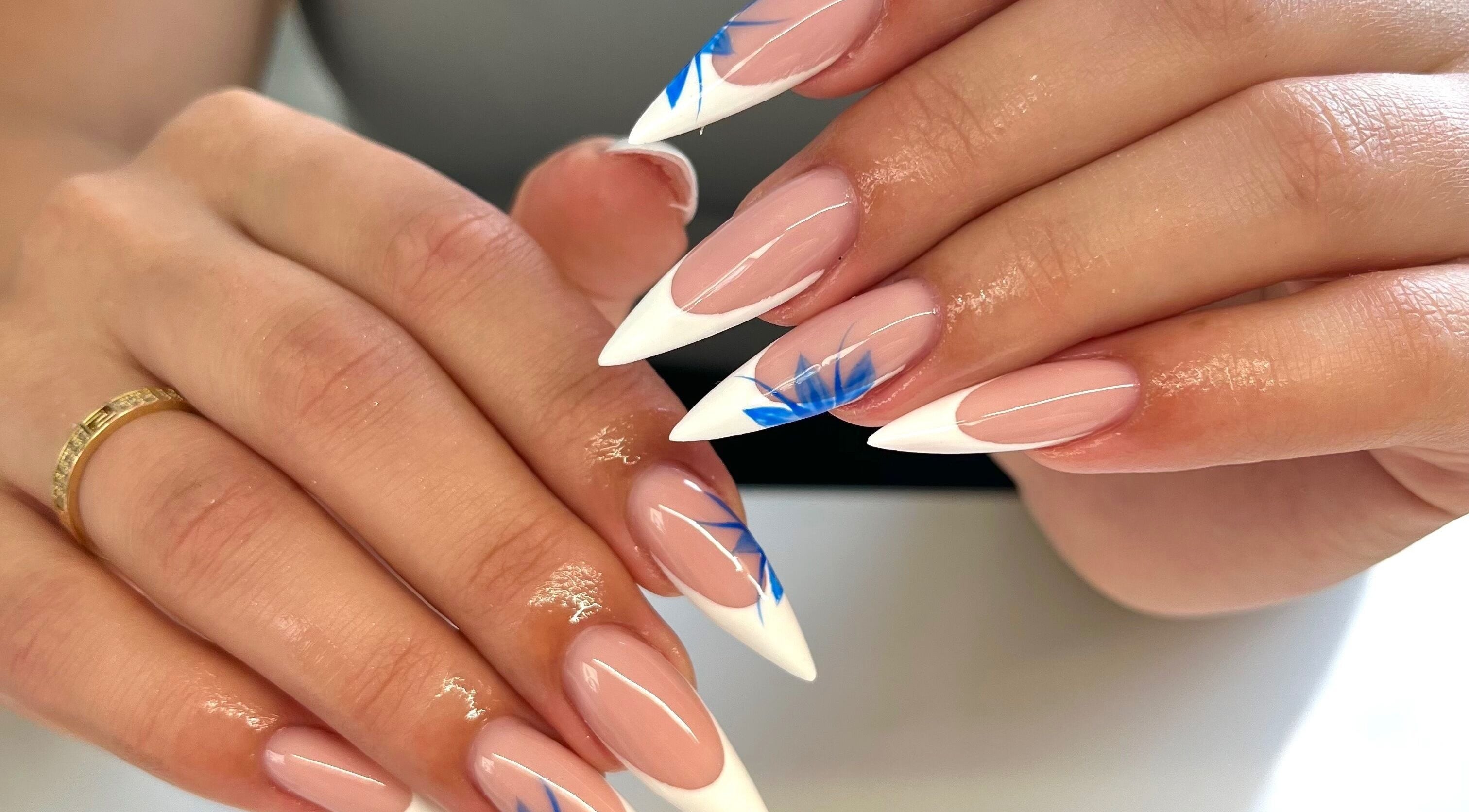 Elegant stiletto nails with blue accents by Nails by Ray, Chelmsford, England, GB.