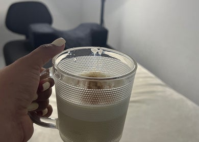 Hand holding coffee cup in cozy setting at Paolashes, Panamá, Provincia De Panamá, PA.