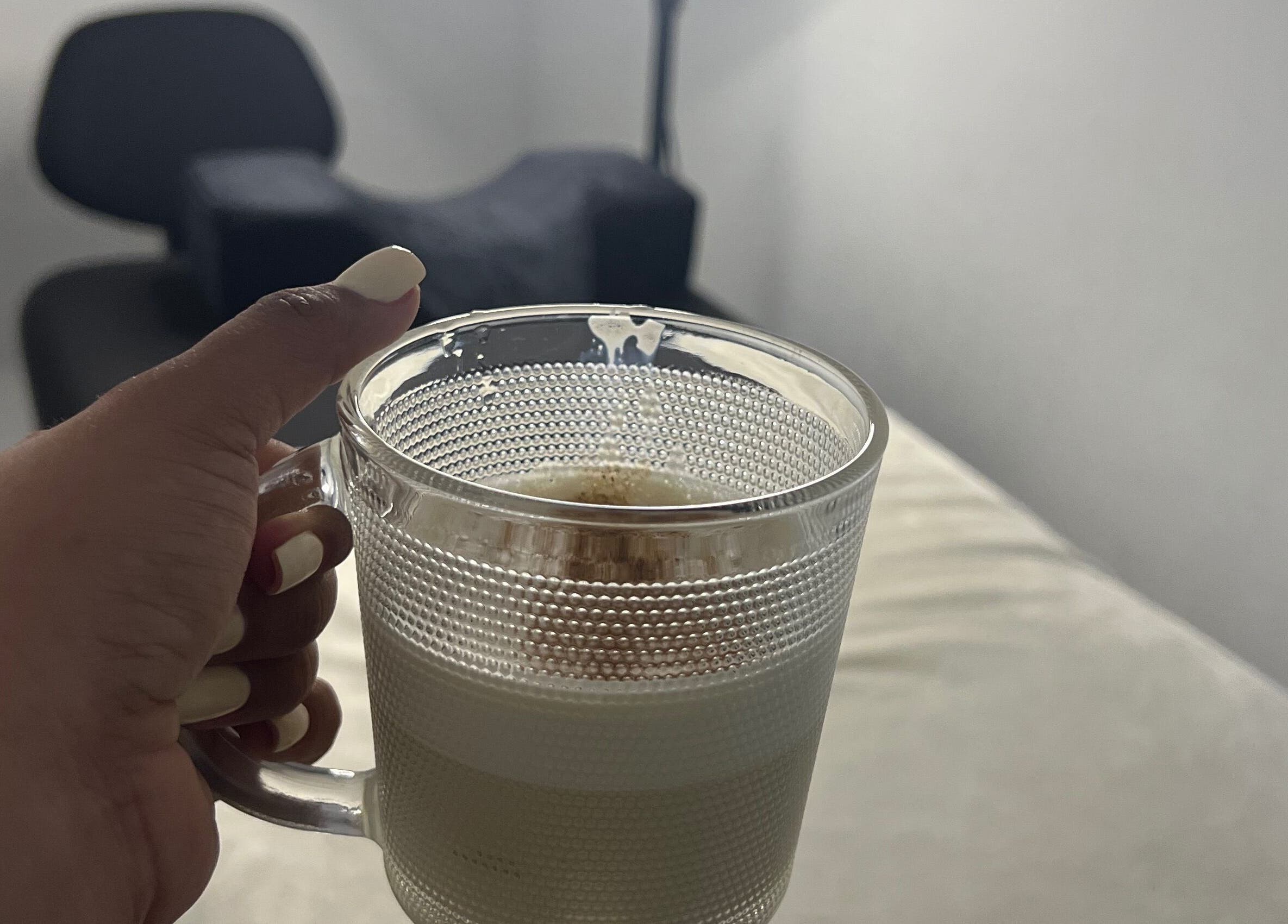 Hand holding coffee cup in cozy setting at Paolashes, Panamá, Provincia De Panamá, PA.