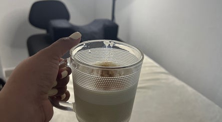 Hand holding coffee cup in cozy setting at Paolashes, Panamá, Provincia De Panamá, PA.