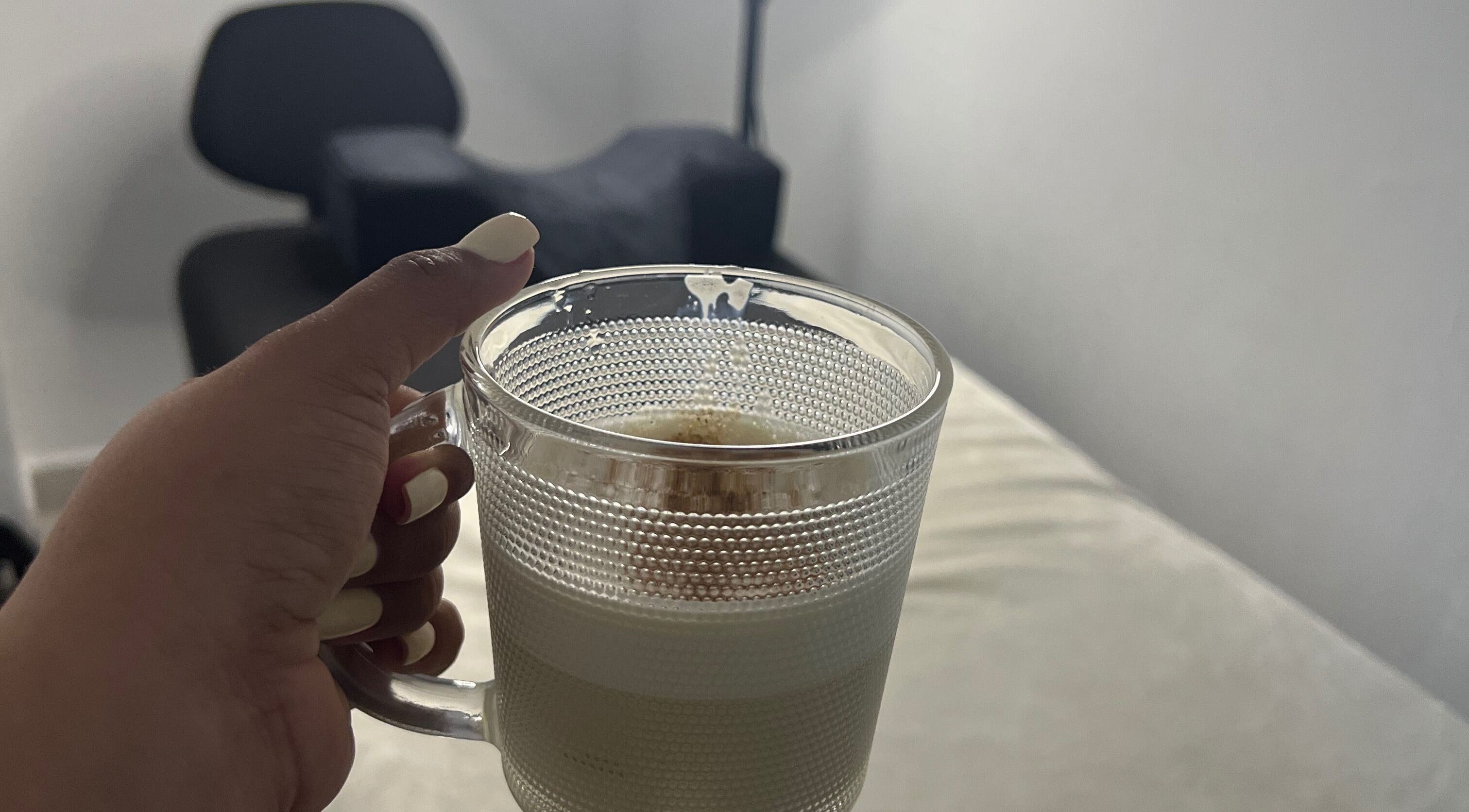 Hand holding coffee cup in cozy setting at Paolashes, Panamá, Provincia De Panamá, PA.