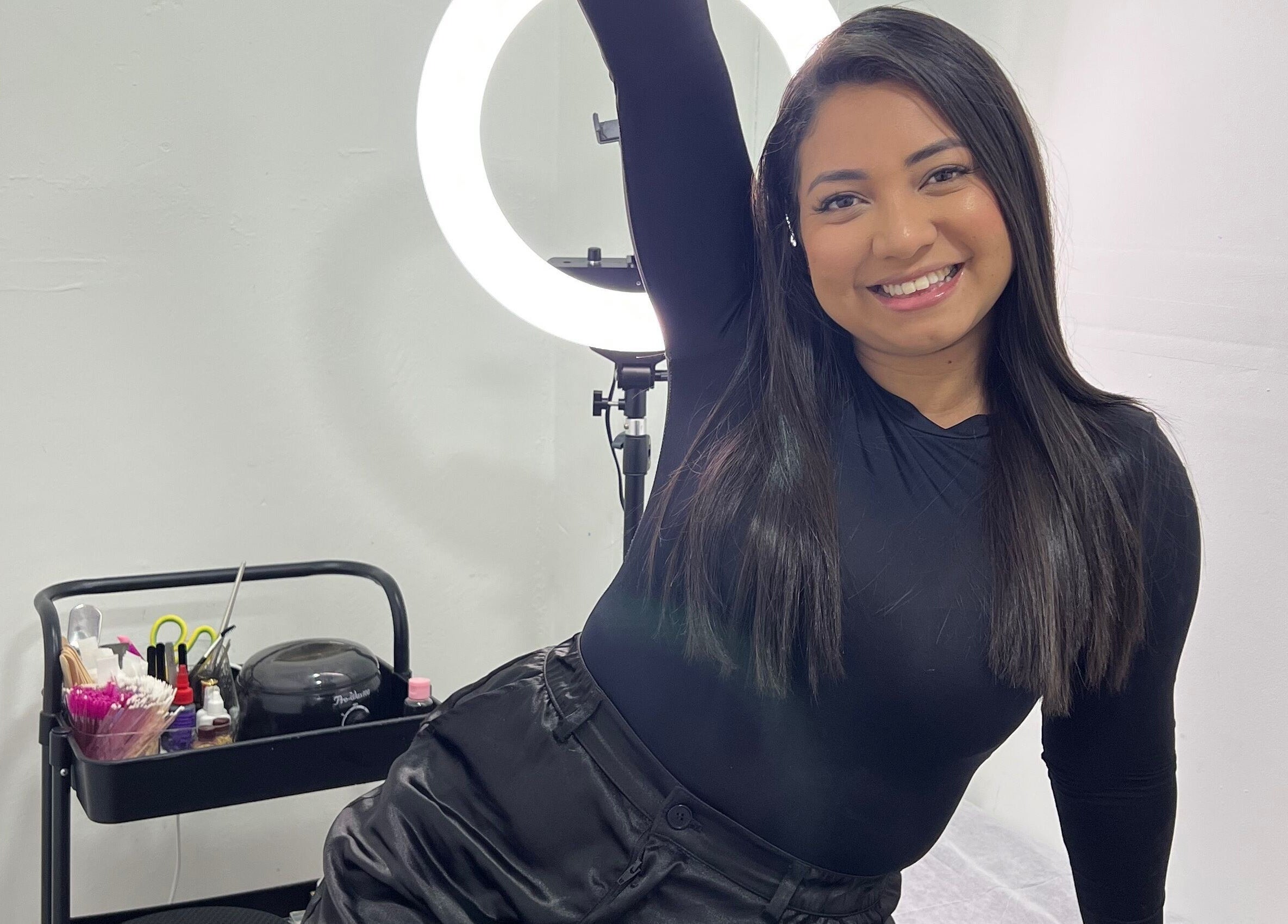 Smiling woman at Paolashes in Panamá, Provincia De Panamá, PA, with beauty tools and ring light.