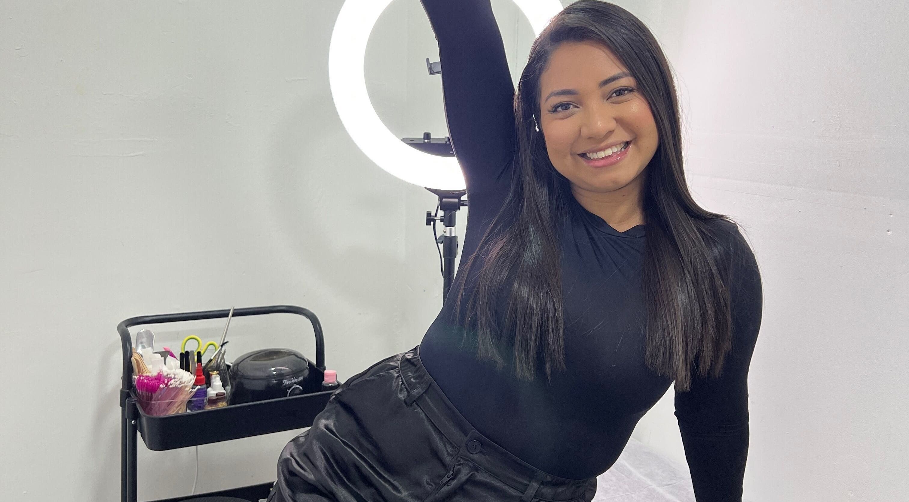 Smiling woman at Paolashes in Panamá, Provincia De Panamá, PA, with beauty tools and ring light.