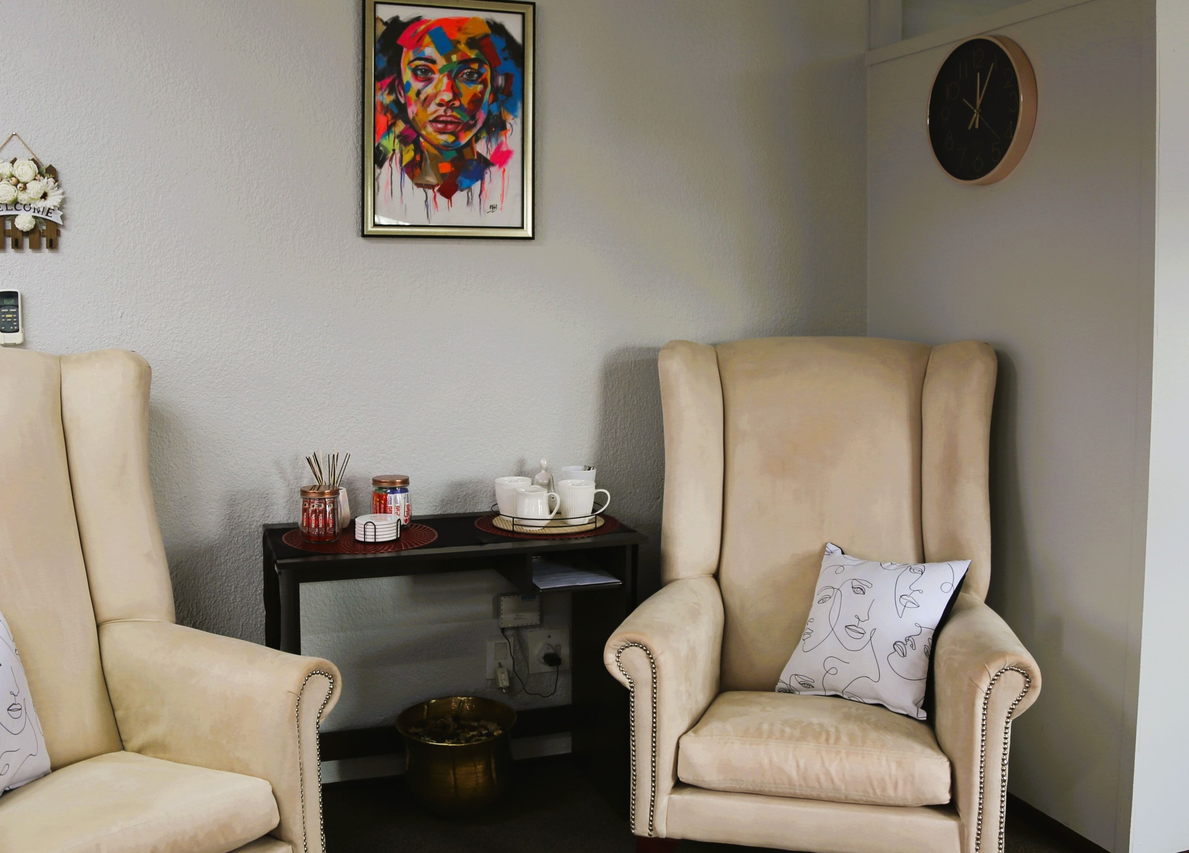 Cozy interior of OCD Permanent MakeUp in Krugersdorp, Gauteng, ZA with plush chairs and vibrant artwork.