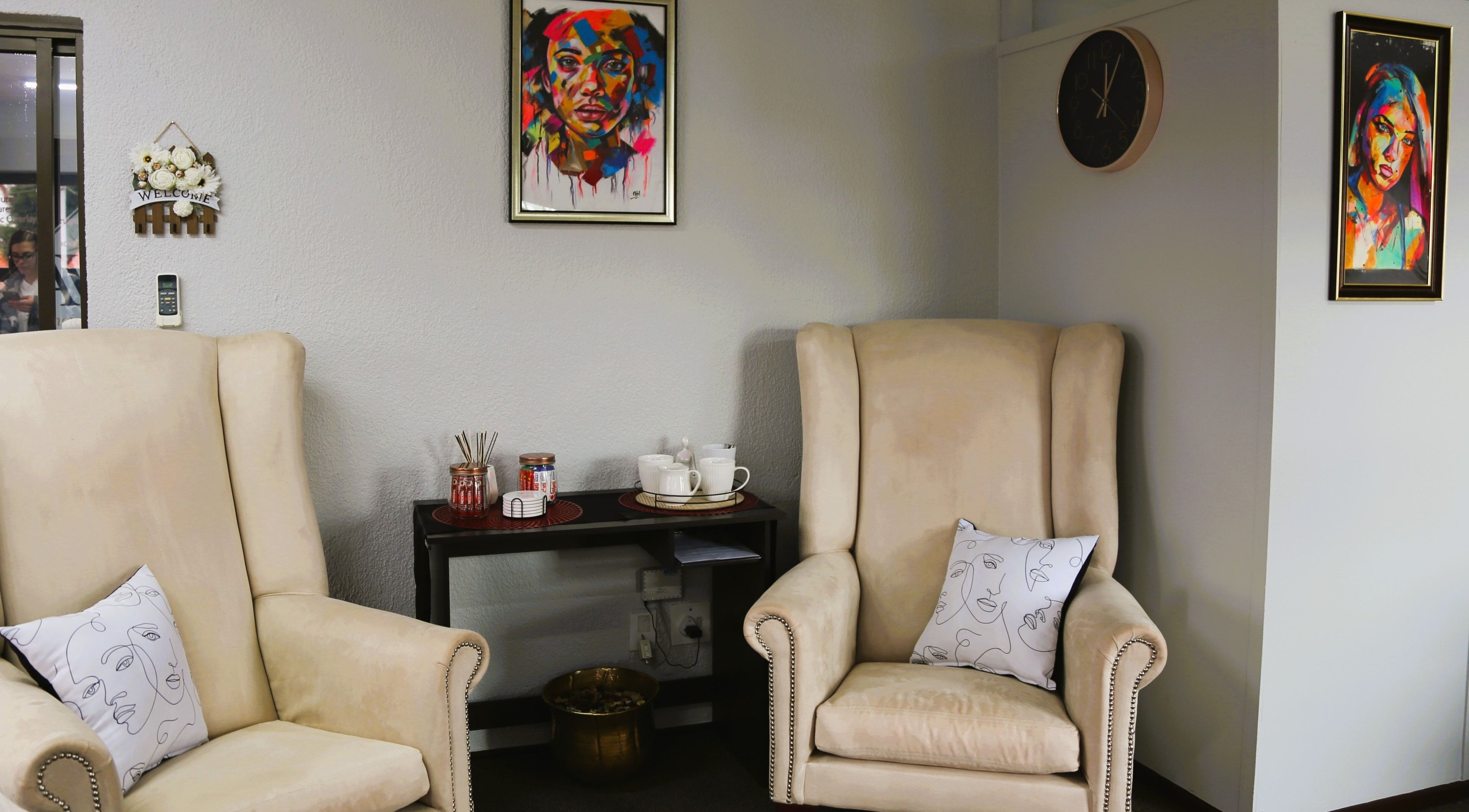 Cozy interior of OCD Permanent MakeUp in Krugersdorp, Gauteng, ZA with plush chairs and vibrant artwork.