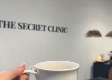 Cozy ambiance at The Brow Secret, Stoke Gifford, England, GB with a hand holding a white coffee cup.