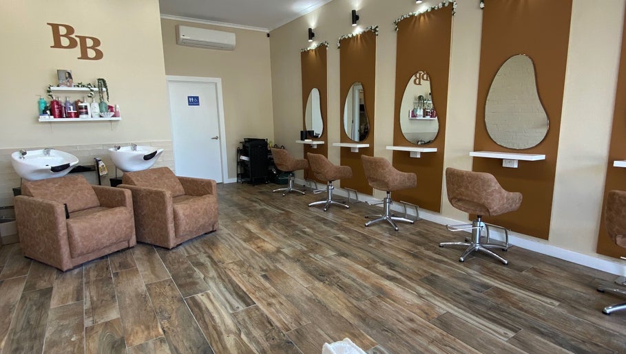 Modern salon interior at Hairbyloisbodie, Randwick, New South Wales, AU with stylish chairs and wash stations.