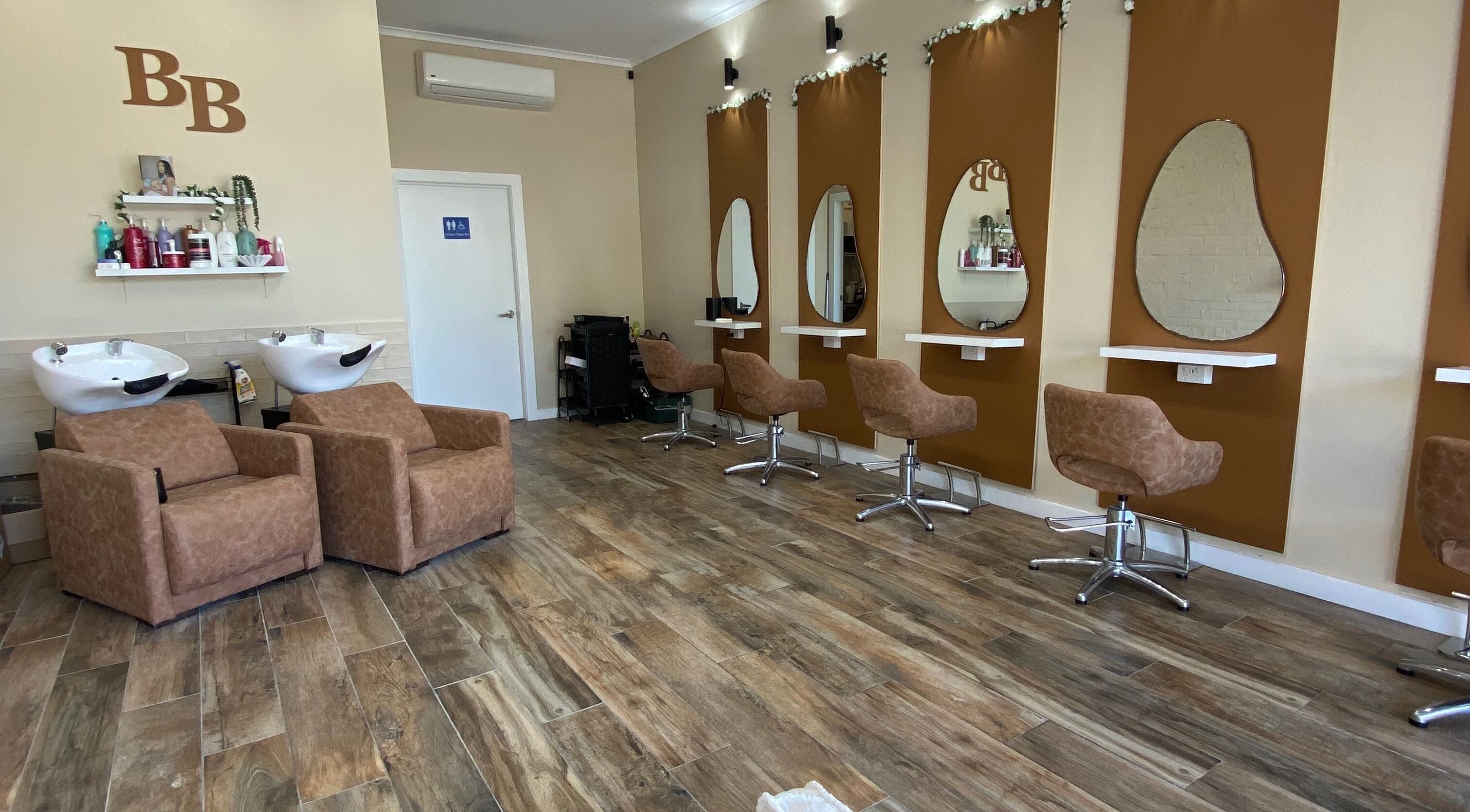 Modern salon interior at Hairbyloisbodie, Randwick, New South Wales, AU with stylish chairs and wash stations.