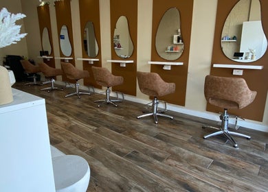 Modern salon interior at Hairbyloisbodie in Randwick, New South Wales, AU with stylish brown chairs and unique mirrors.
