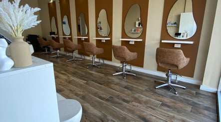 Modern salon interior at Hairbyloisbodie in Randwick, New South Wales, AU with stylish brown chairs and unique mirrors.