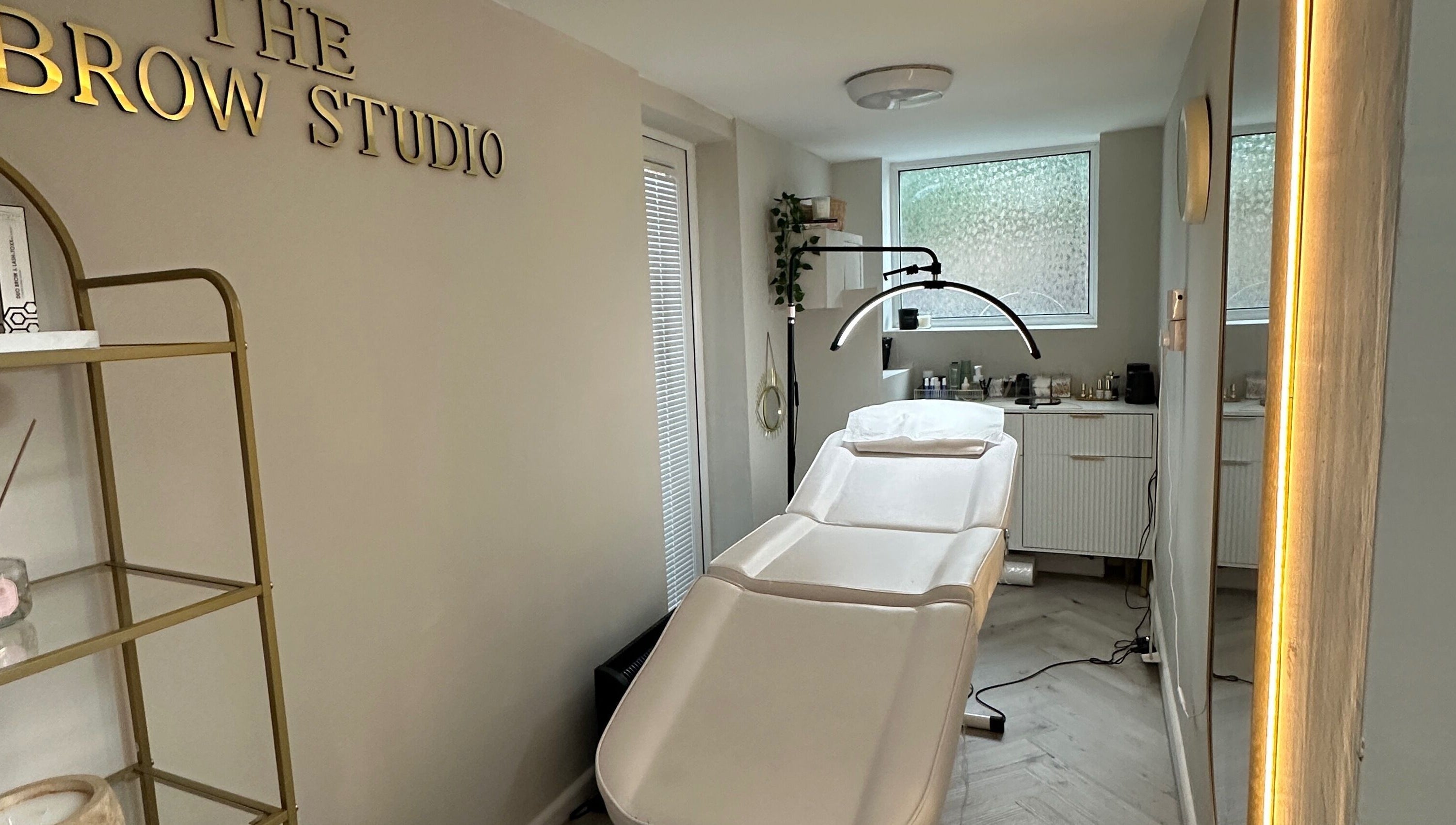 Relaxing interior of The Brow Studio in Wythenshawe, England featuring treatment bed and elegant decor.