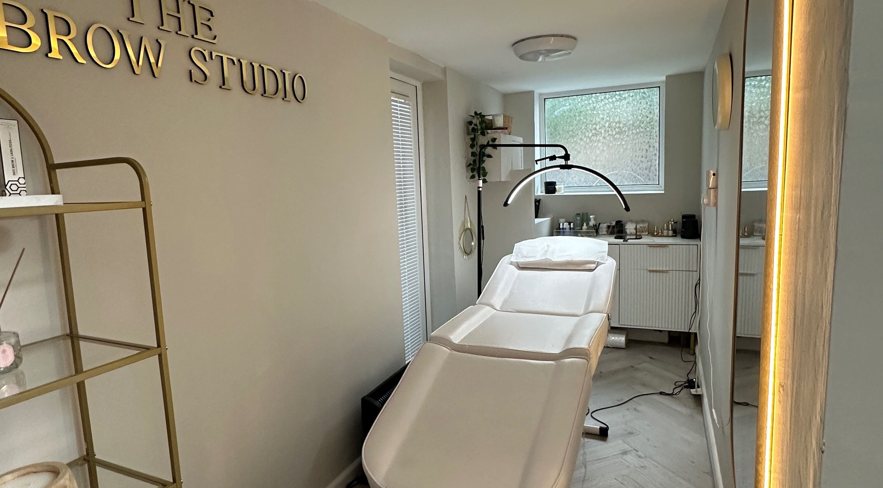 Relaxing interior of The Brow Studio in Wythenshawe, England featuring treatment bed and elegant decor.