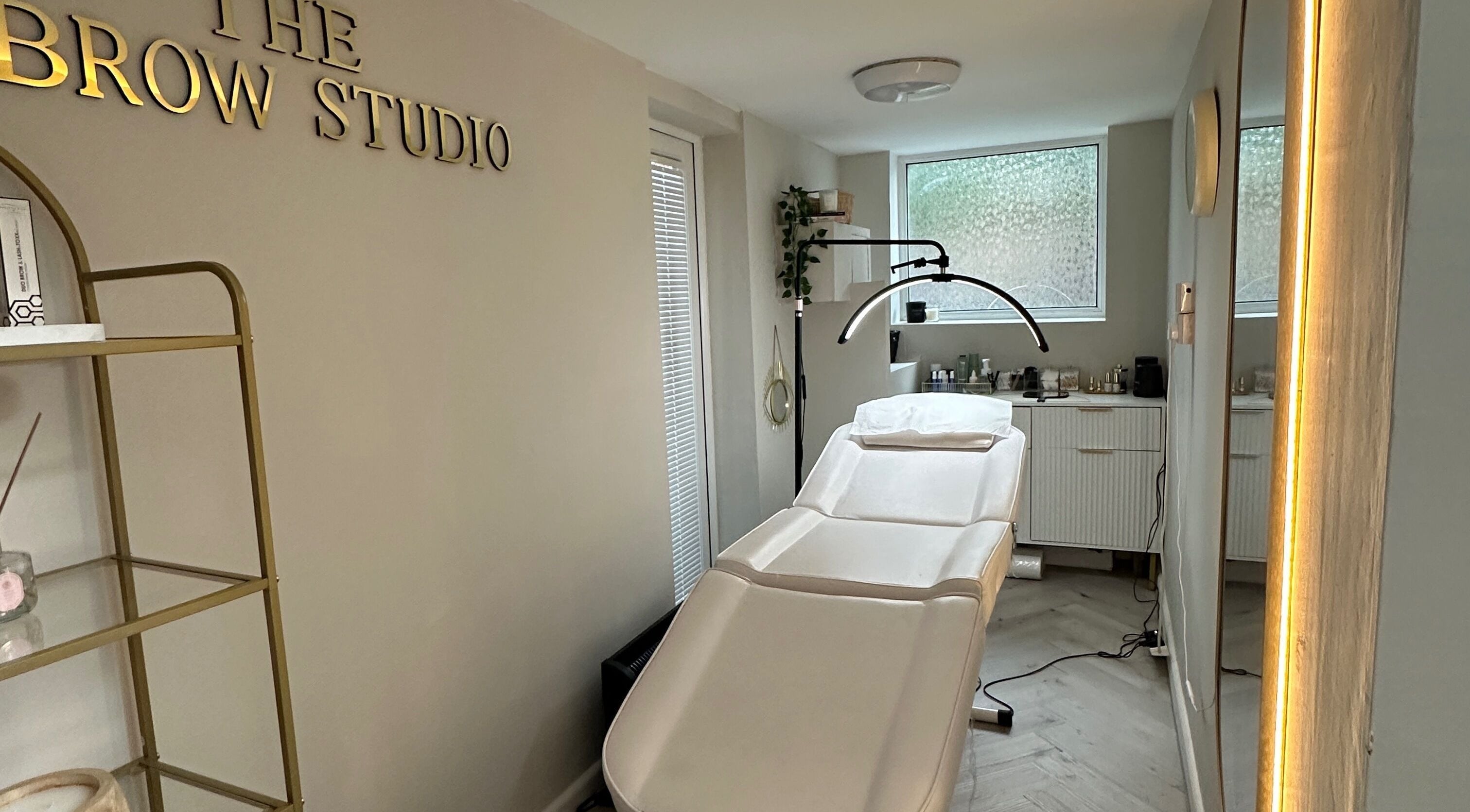 Relaxing interior of The Brow Studio in Wythenshawe, England featuring treatment bed and elegant decor.