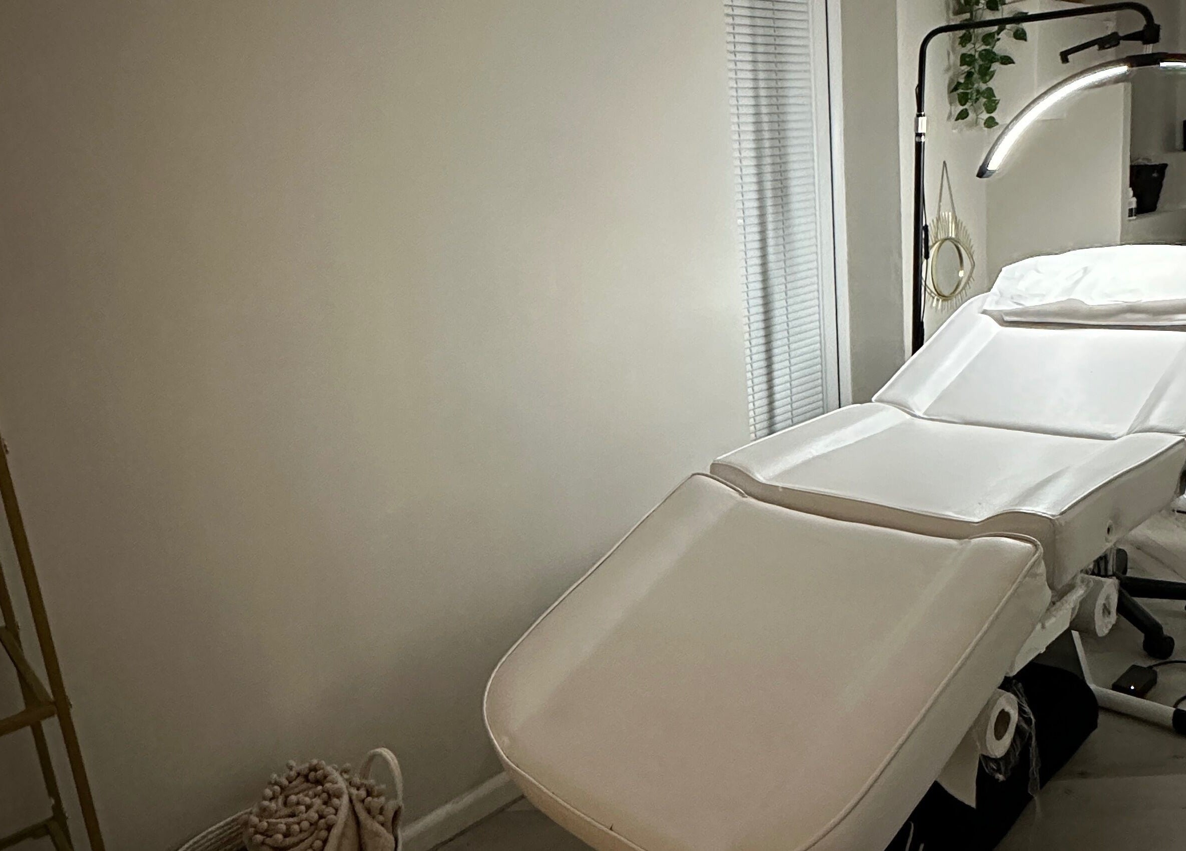 A serene treatment room at The Brow Studio in Wythenshawe, England, GB, featuring a plush white bed.