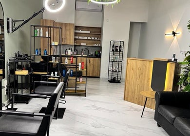 Άνετο σαλόνι στο Gspot Hair Studio, Ilioupoli, GR με μοντέρνα επίπλωση και προϊόντα ομορφιάς.