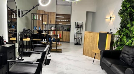 Άνετο σαλόνι στο Gspot Hair Studio, Ilioupoli, GR με μοντέρνα επίπλωση και προϊόντα ομορφιάς.